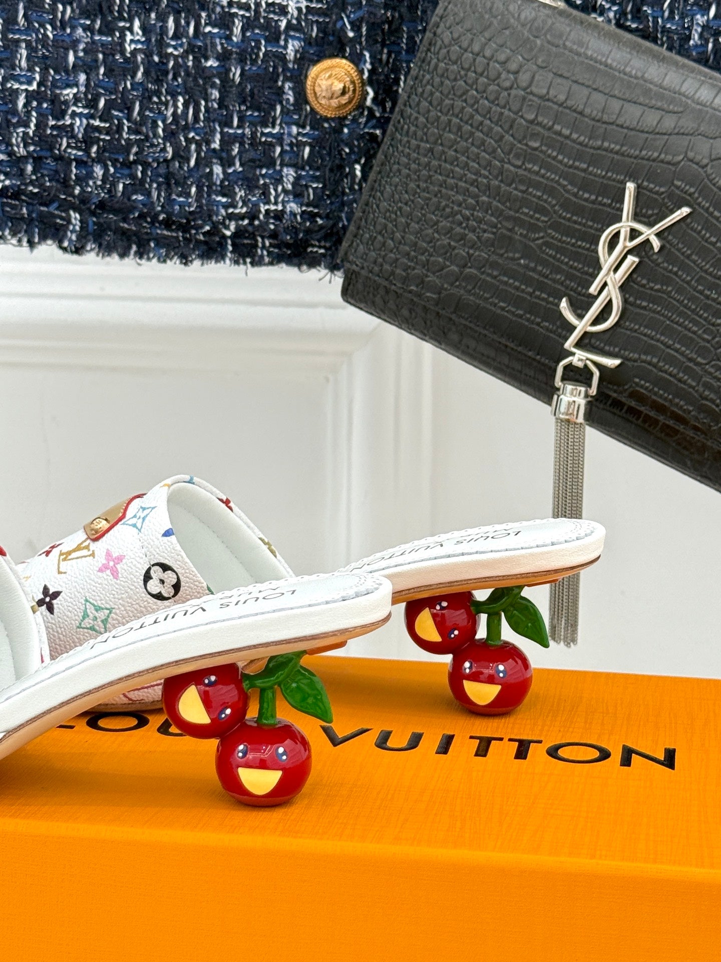 White monogram slide sandals with flat sole and patterned strap detail
