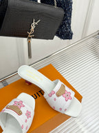 White floral slide sandals with pink flower print and gold buckled strap