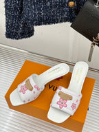 White slide sandals with pink floral pattern, gold buckle strap, open toe