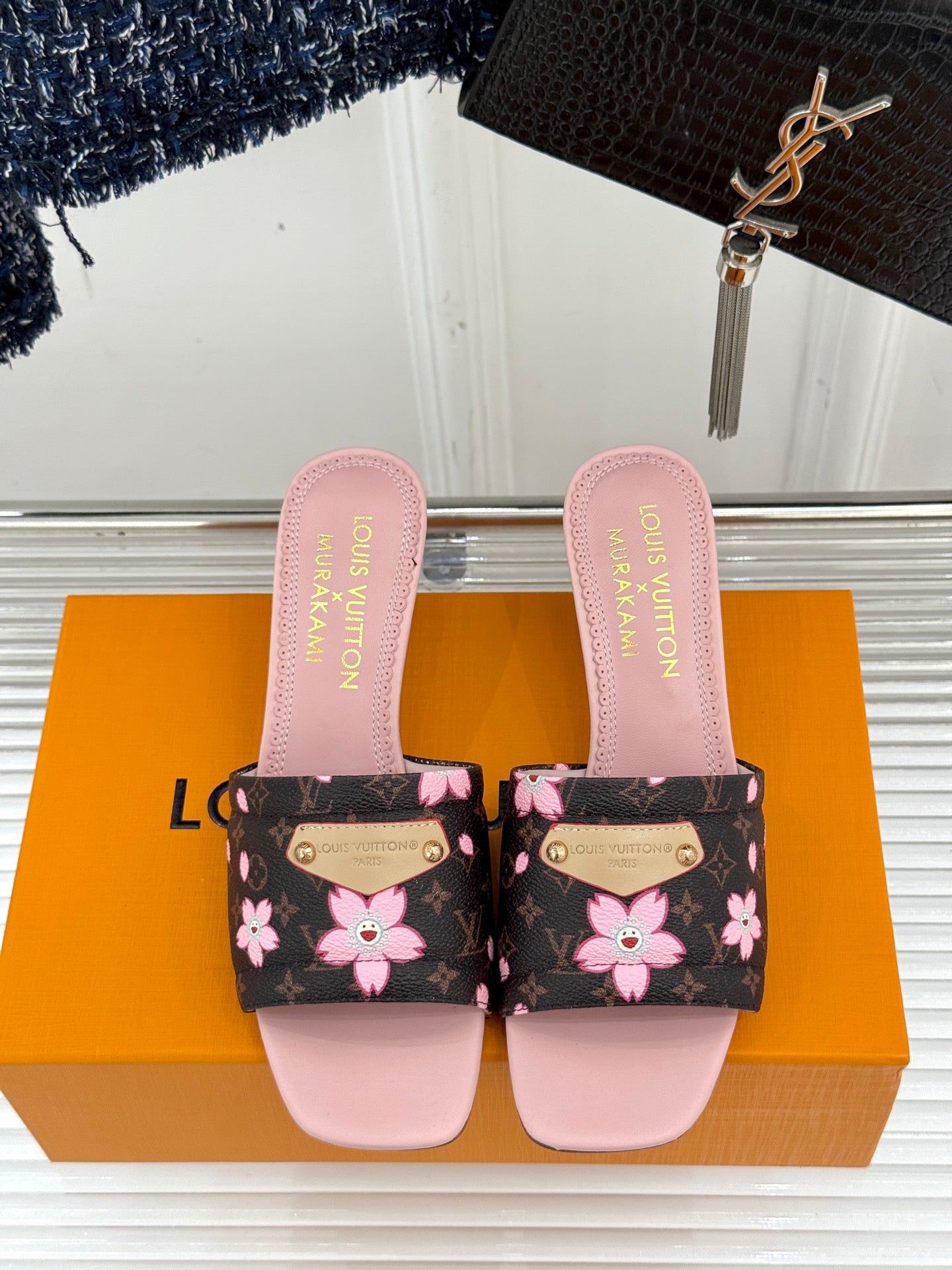 Louis Vuitton slide sandals showing two-tone pink straps and floral black pattern