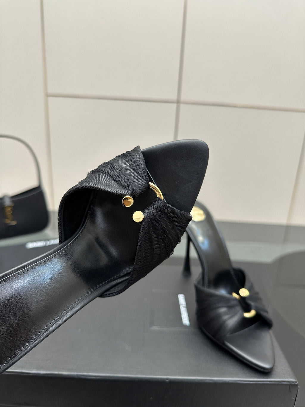 Black leather mule upper with gold button hardware and tall stiletto heel