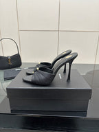 Black leather slide mules with gold hardware and sleek stiletto heels