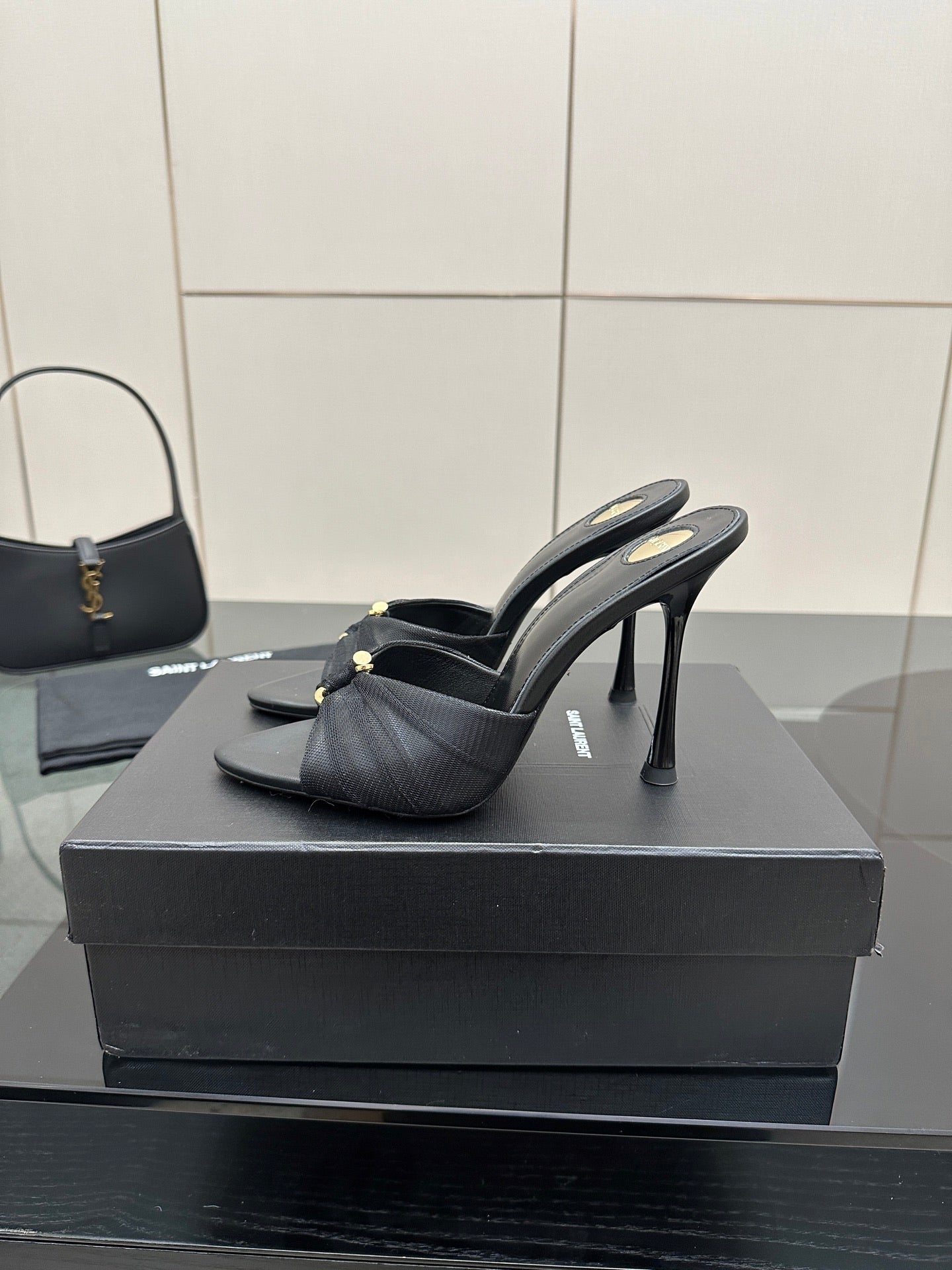 Black leather slide mules with gold hardware and sleek stiletto heels
