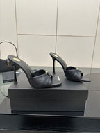 Black leather open-toe mules with gold accent and tall stiletto heels