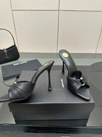 Black leather mule sandals with gold detail and high stiletto heels
