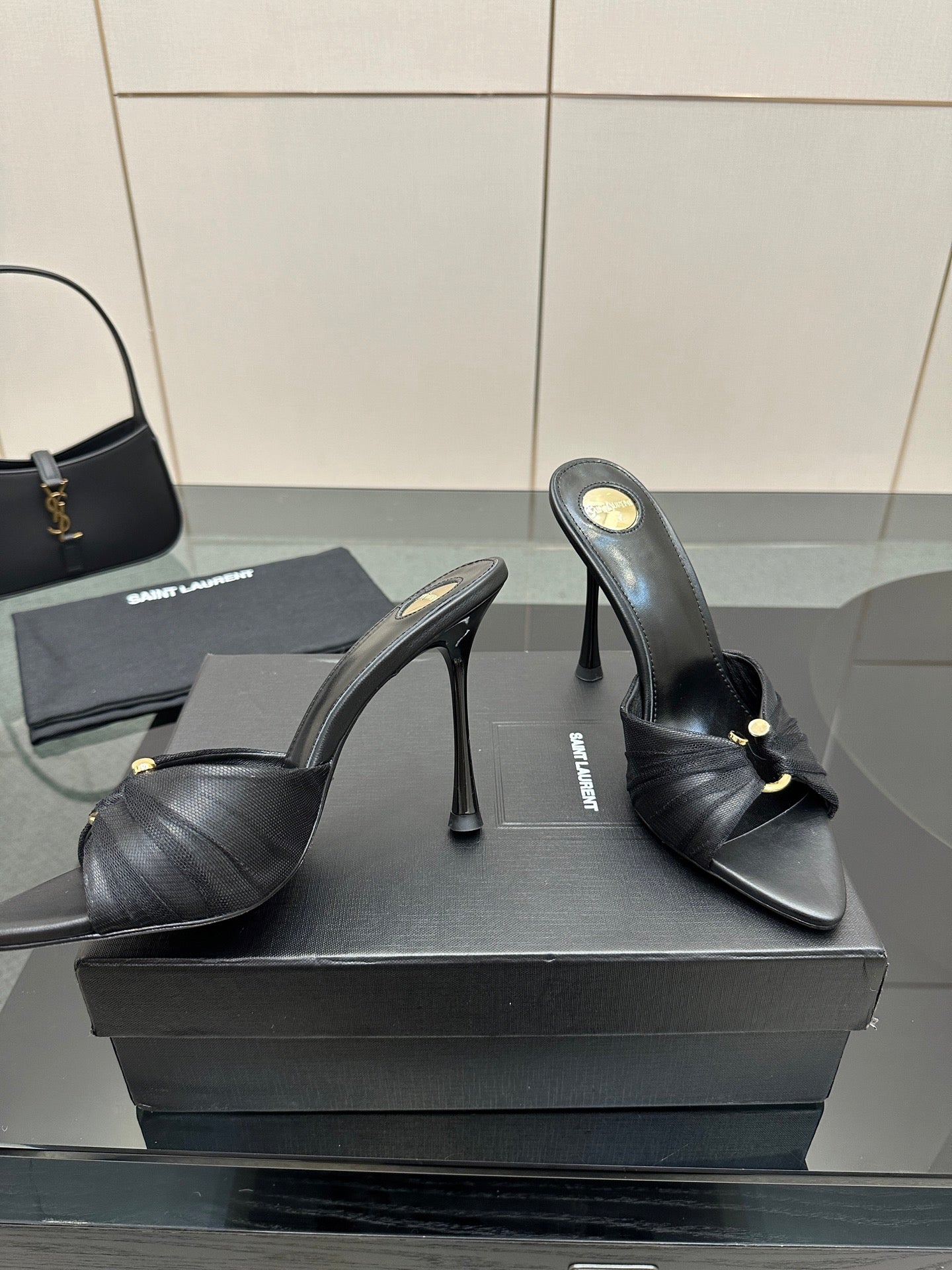 Black leather mule sandals with gold detail and high stiletto heels