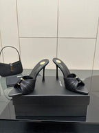 Black leather mule slides with gold button detail and slender stiletto heels