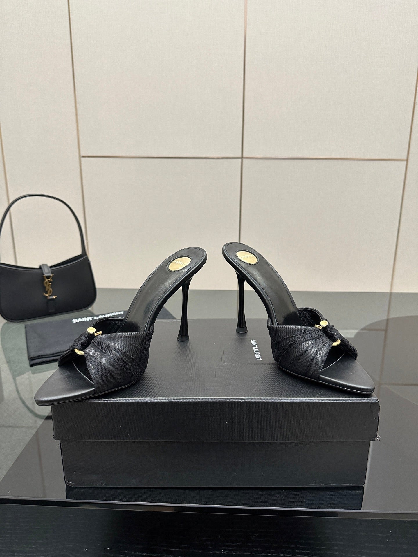Black leather mule slides with gold button detail and slender stiletto heels