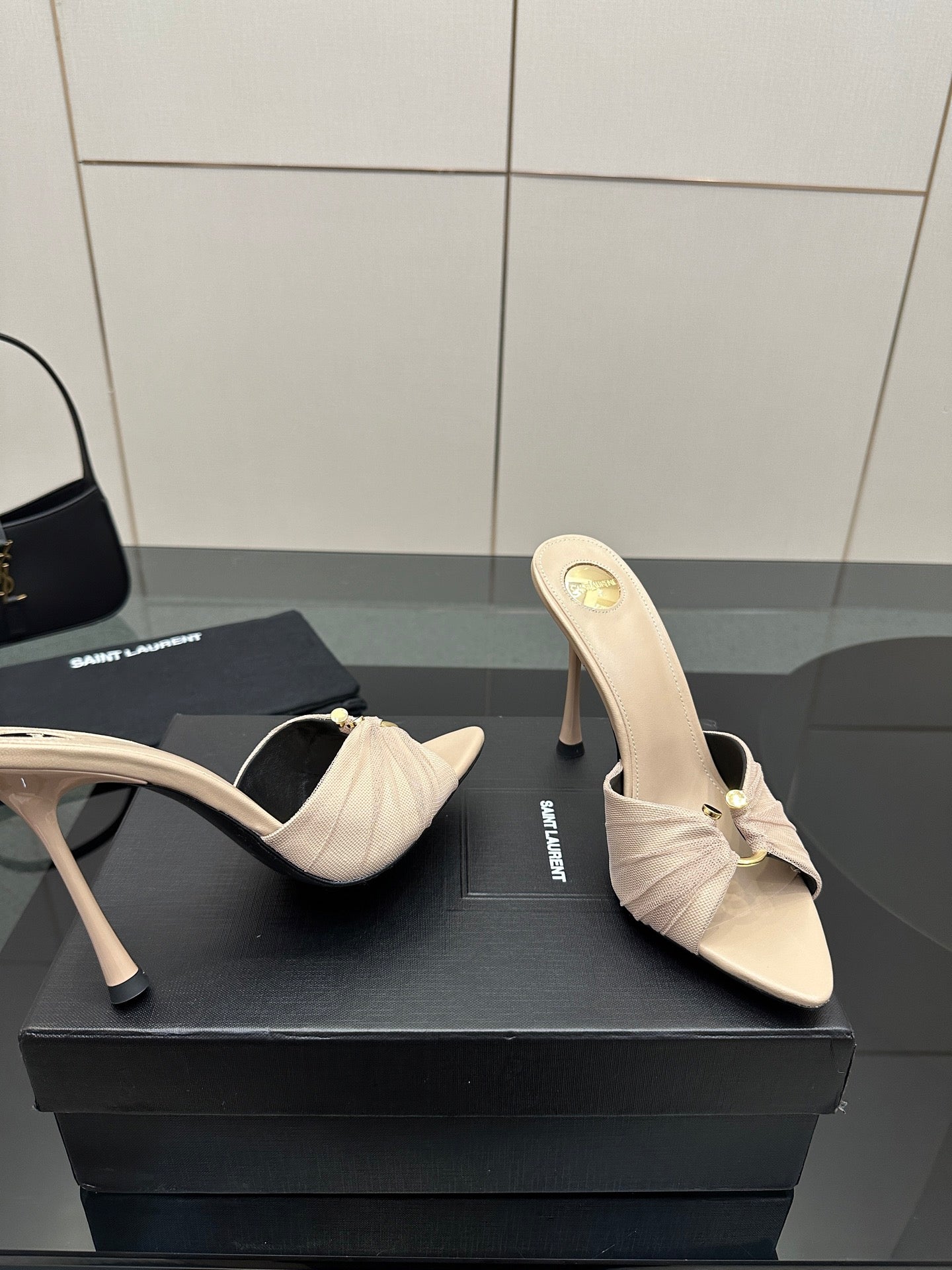 Cream heeled mule sandals with bow detail and slim heel, close-up of toe.