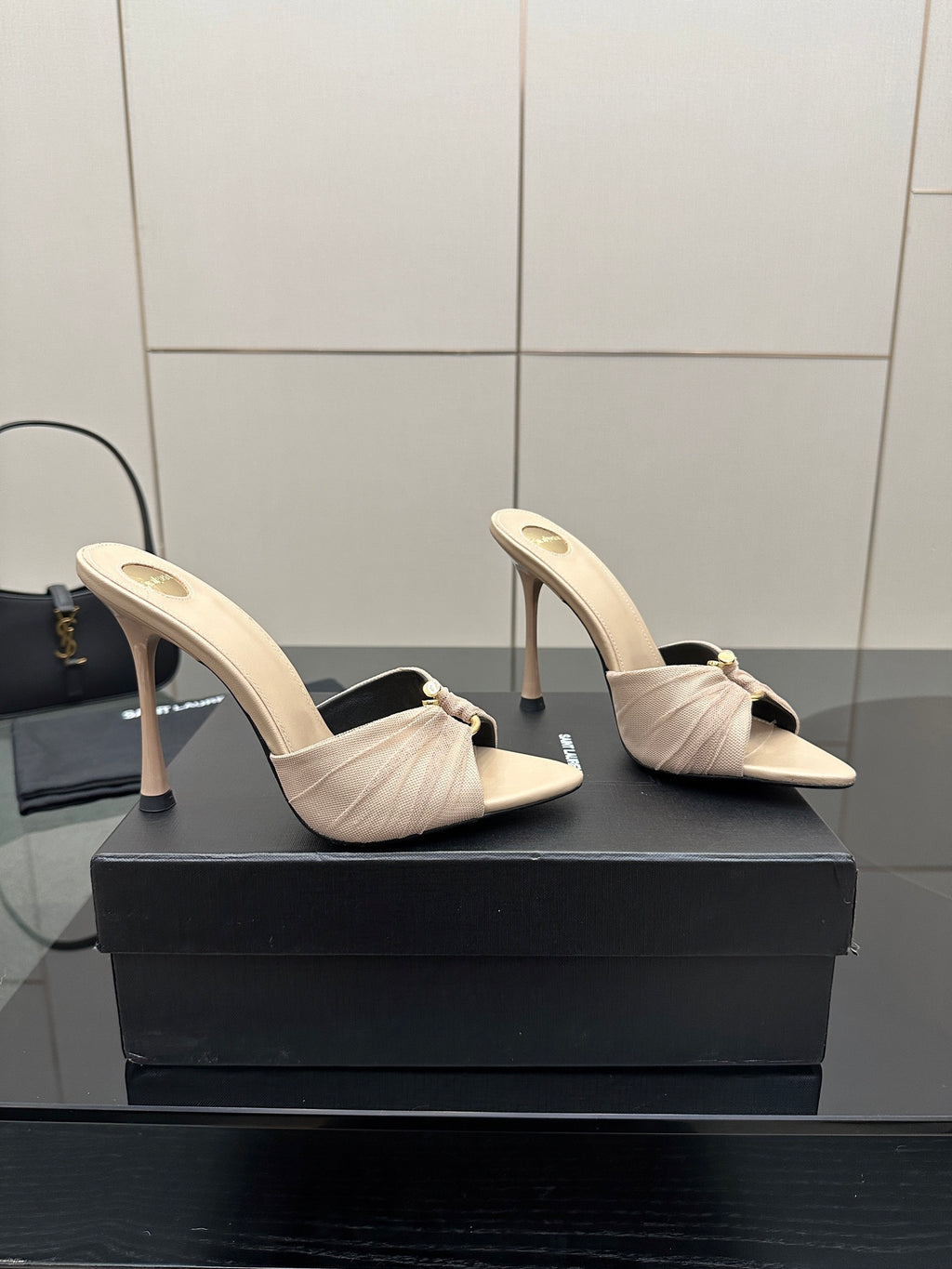 Cream heeled mule sandals with bow strap and slim stiletto heel, angled front.