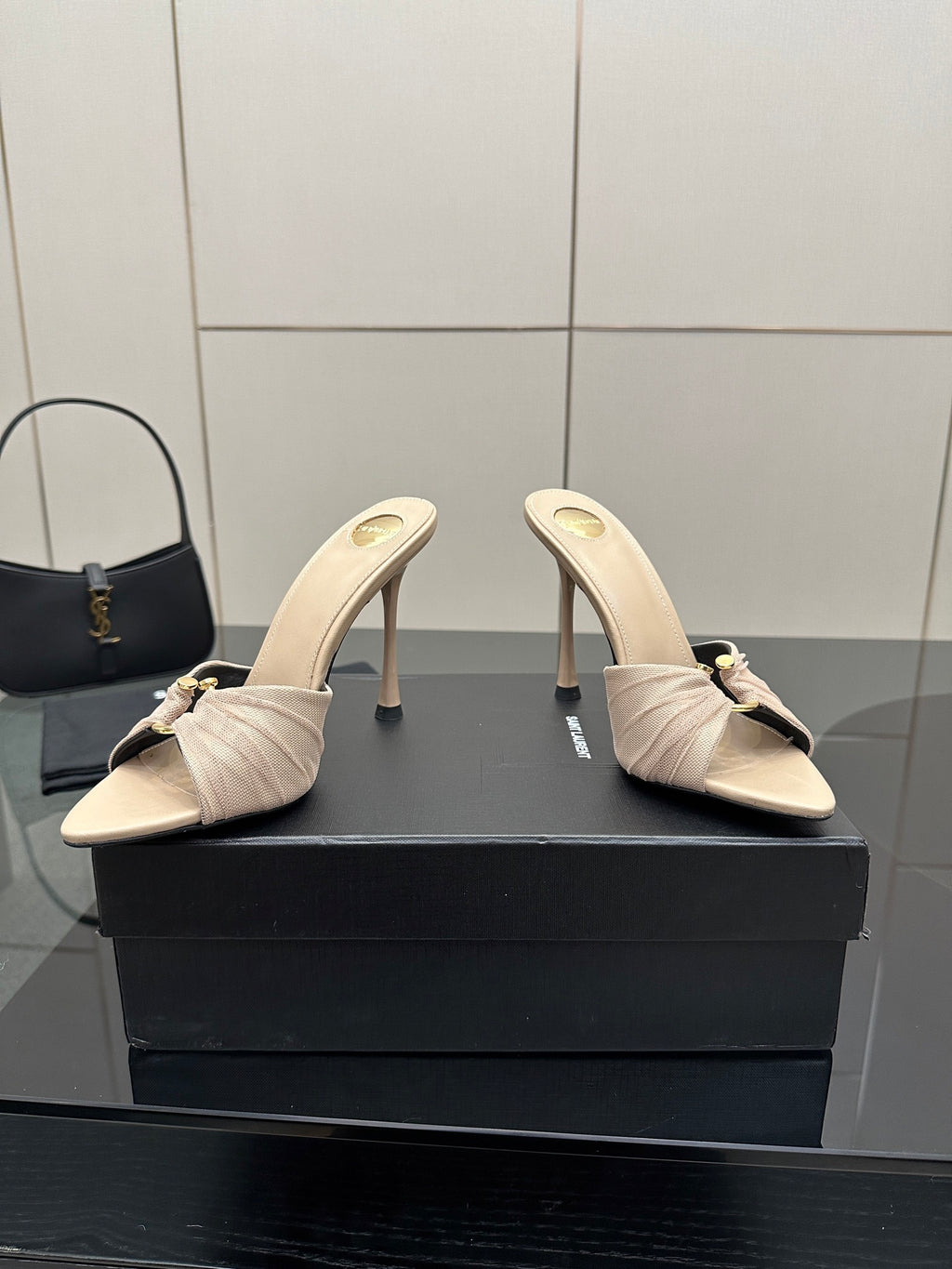 Cream heeled mule sandals with gathered toe and bow, open side angle.