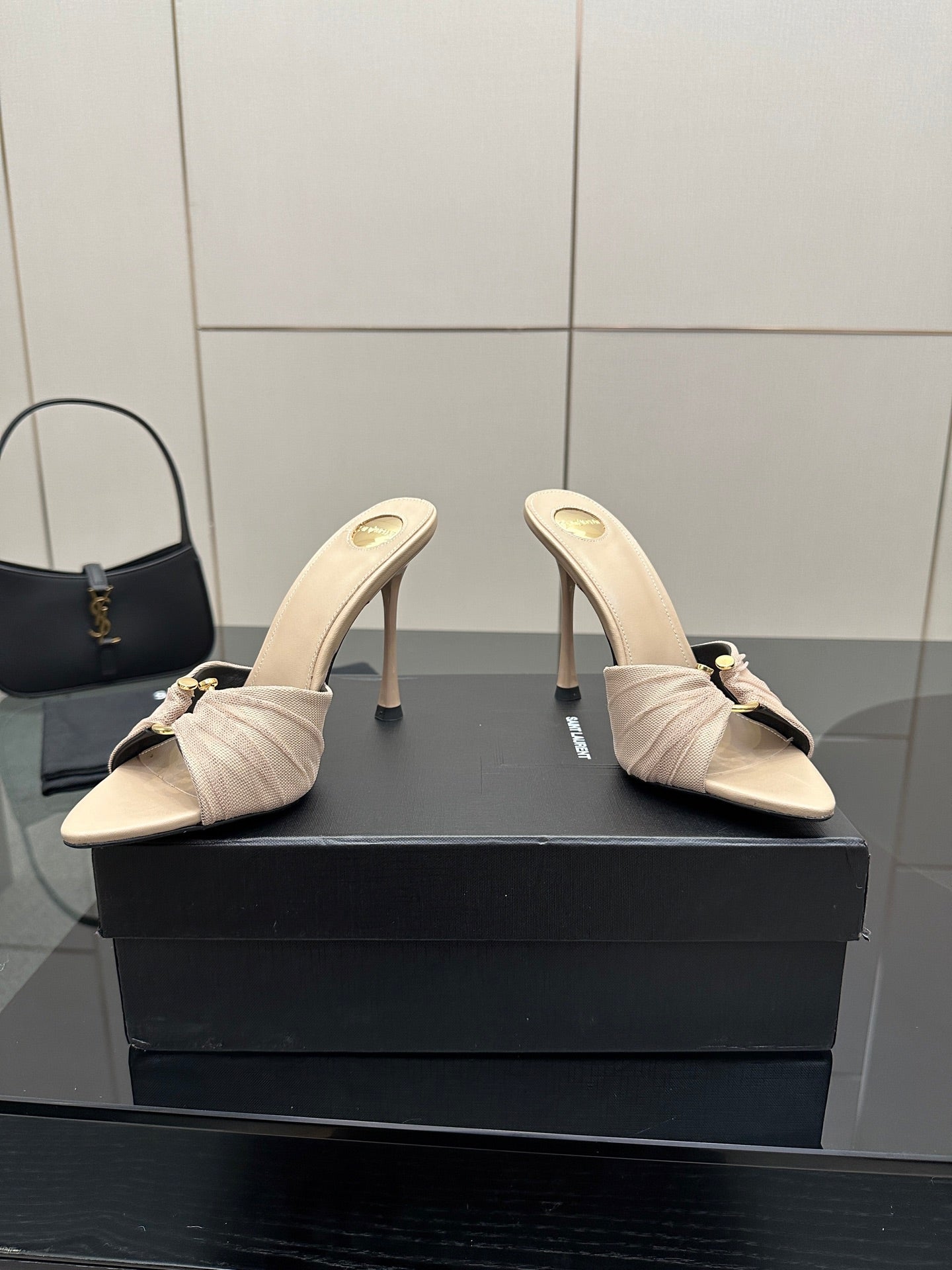 Cream heeled mule sandals with gathered toe and bow, open side angle.