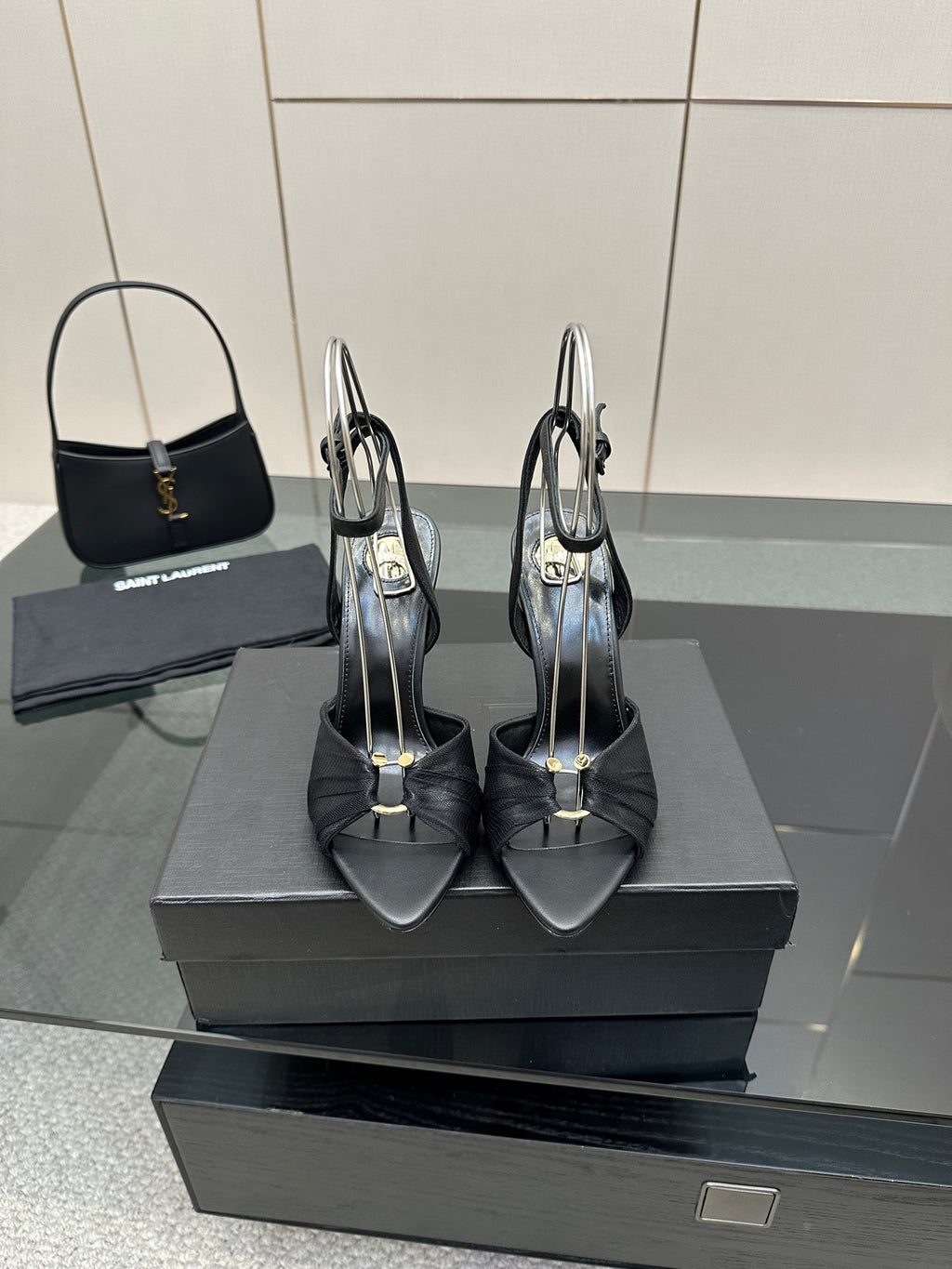 Black open-toe stiletto heeled sandals with ankle strap, pair on display box