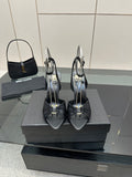 Black open-toe stiletto heeled sandals with ankle strap, pair on display box