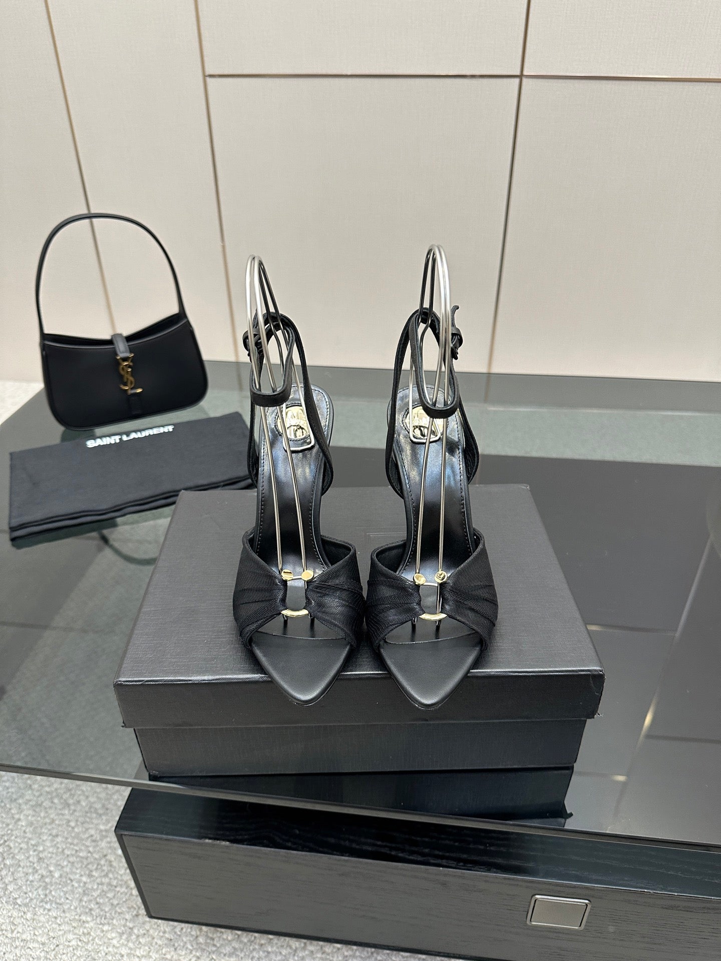 Black open-toe stiletto heeled sandals with ankle strap, pair on display box