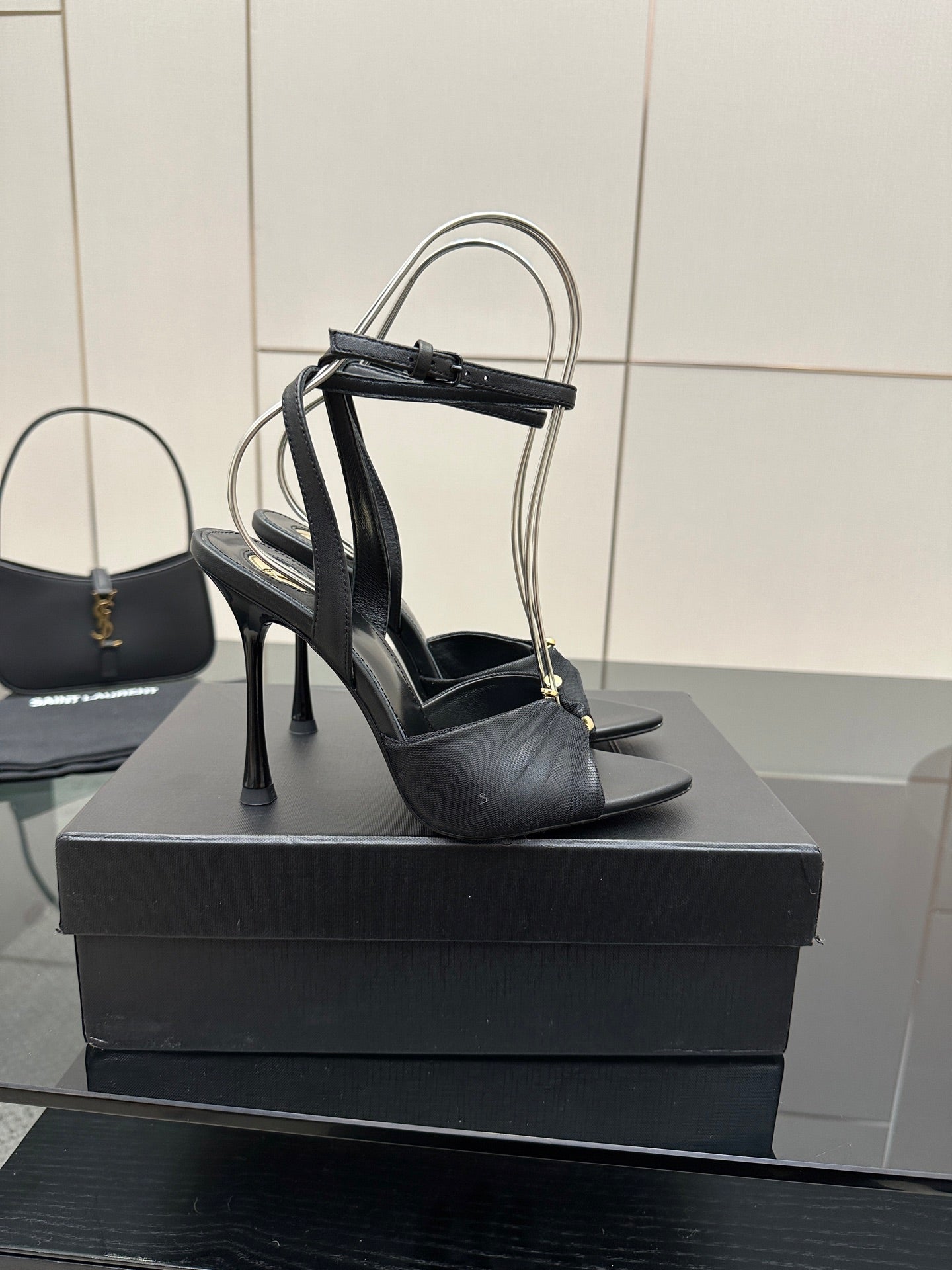 Black strappy stiletto heeled sandals with open toe, shown upright on display