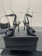 Black high-heel sandals with open toe and ankle strap, pair on display blocks