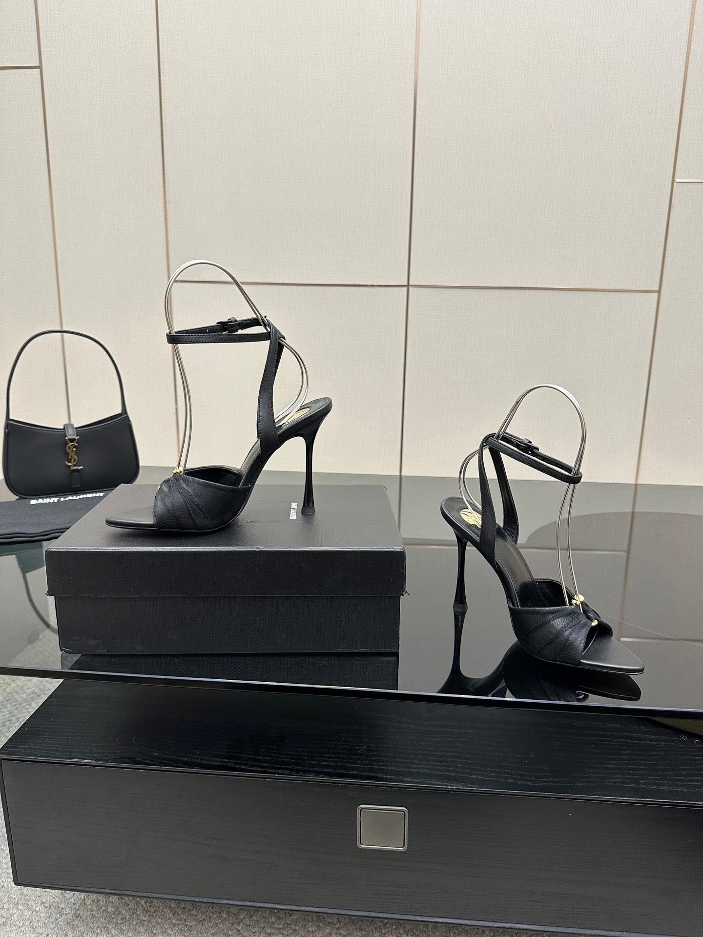 Black open-toe stiletto heeled sandals with ankle strap, single pair on box