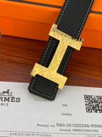 Hermes reversible belt showing gold patterned side with gold H buckle