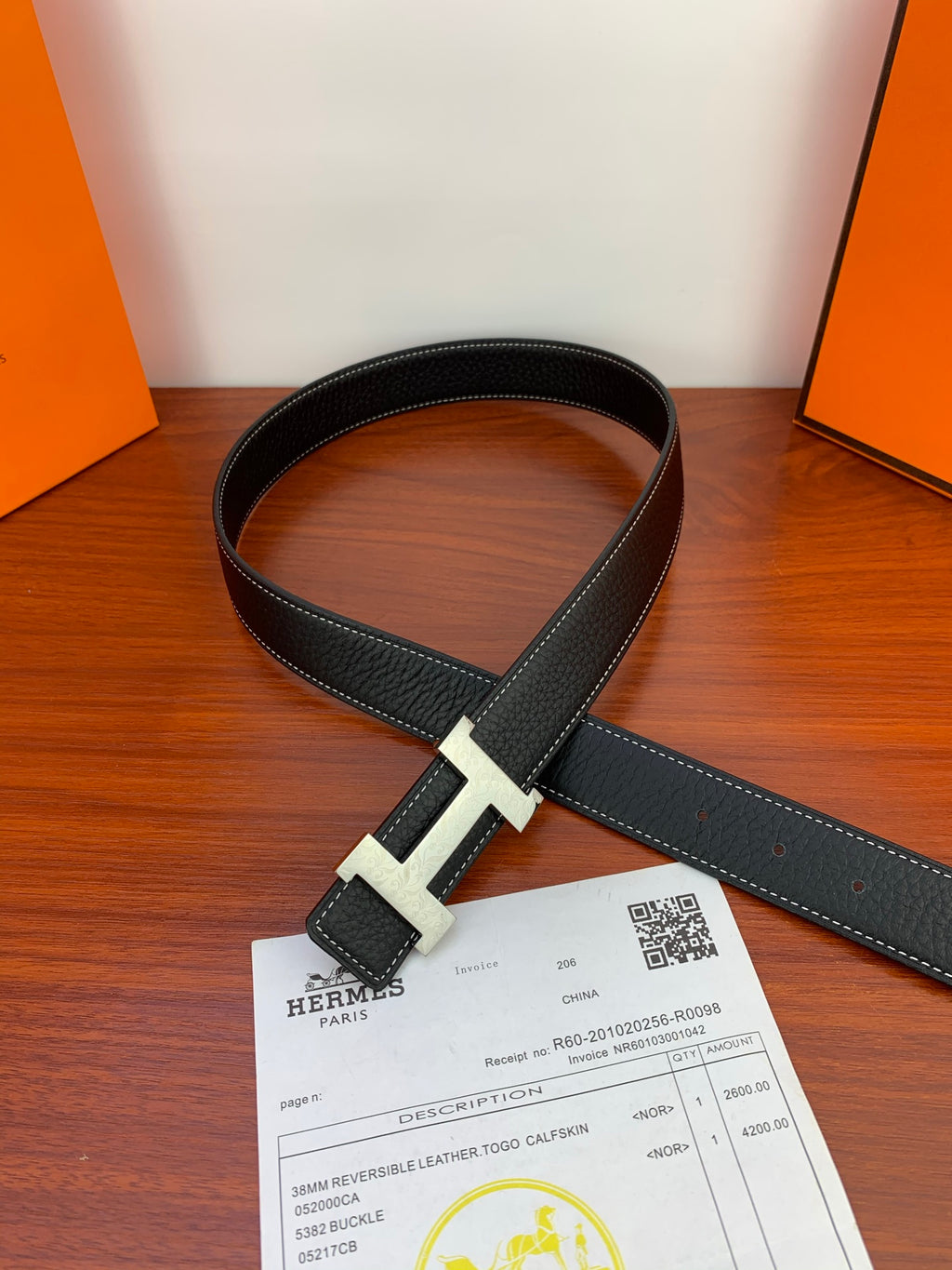 Hermes reversible belt with black strap and silver buckle, laid flat