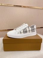 White Burberry low-top sneakers with black check stripe and lace-up front