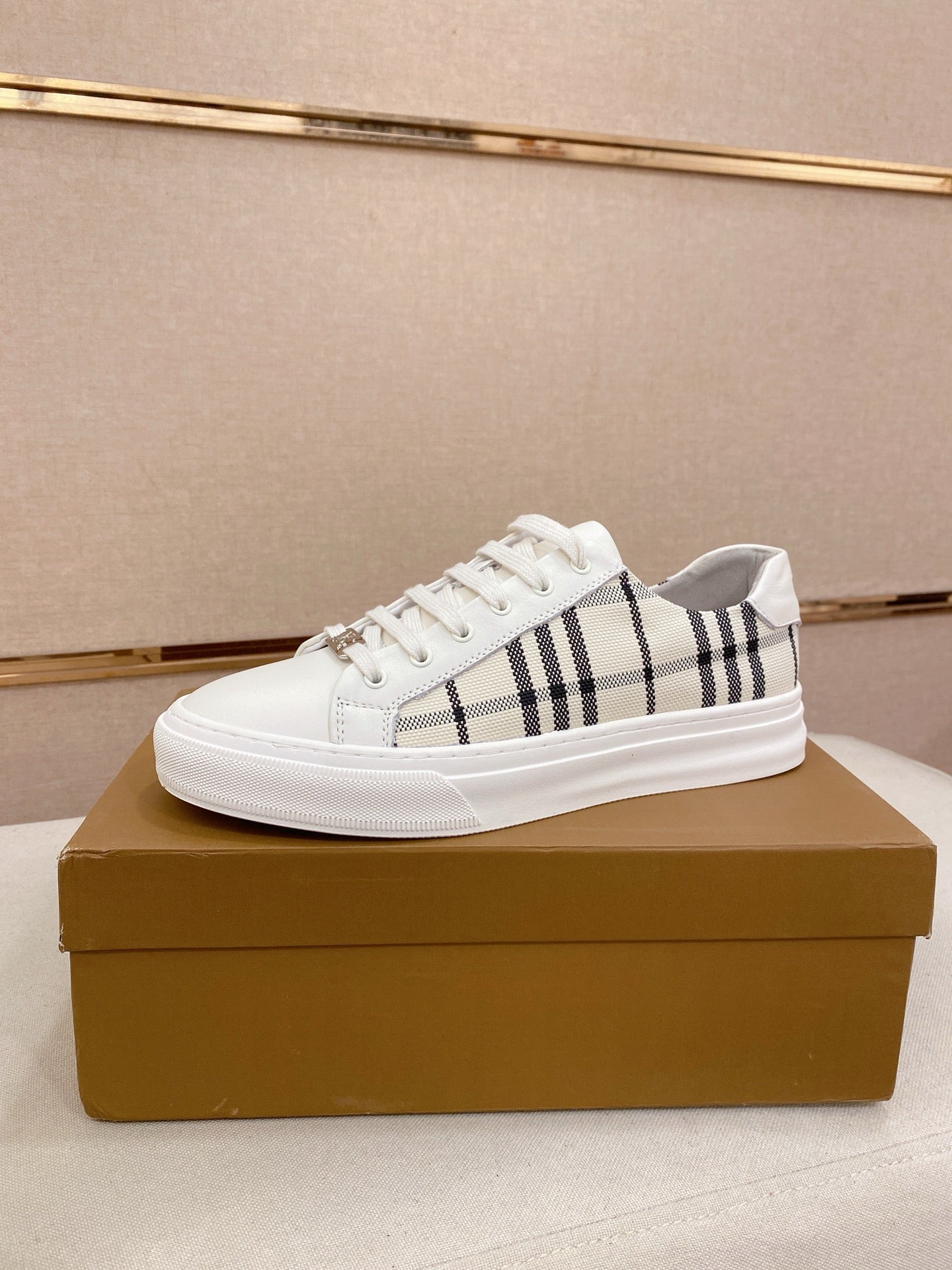 White Burberry low-top sneakers with black check stripe and lace-up front