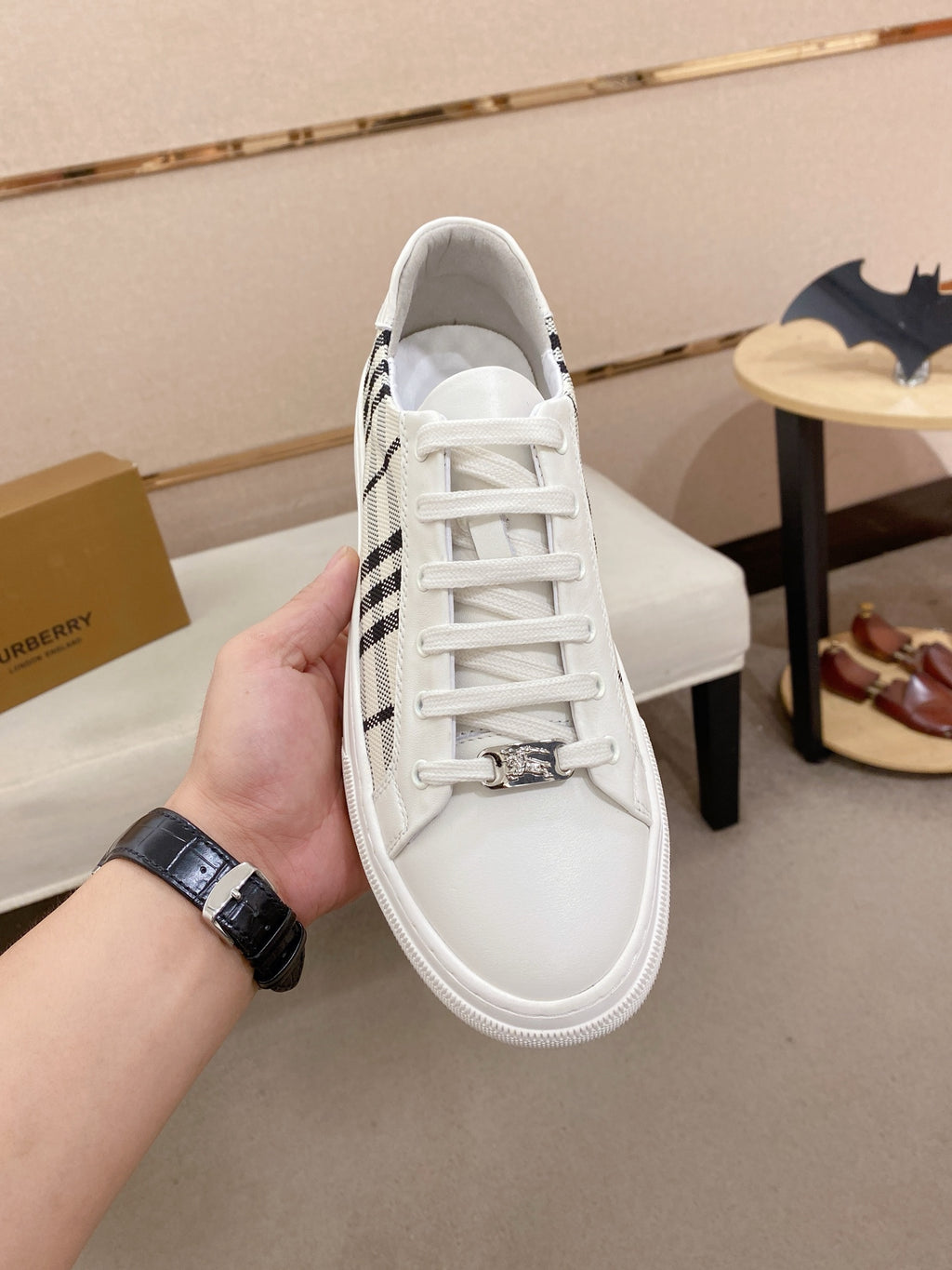 White Burberry sneaker with black check side panel, front laces, and padded collar