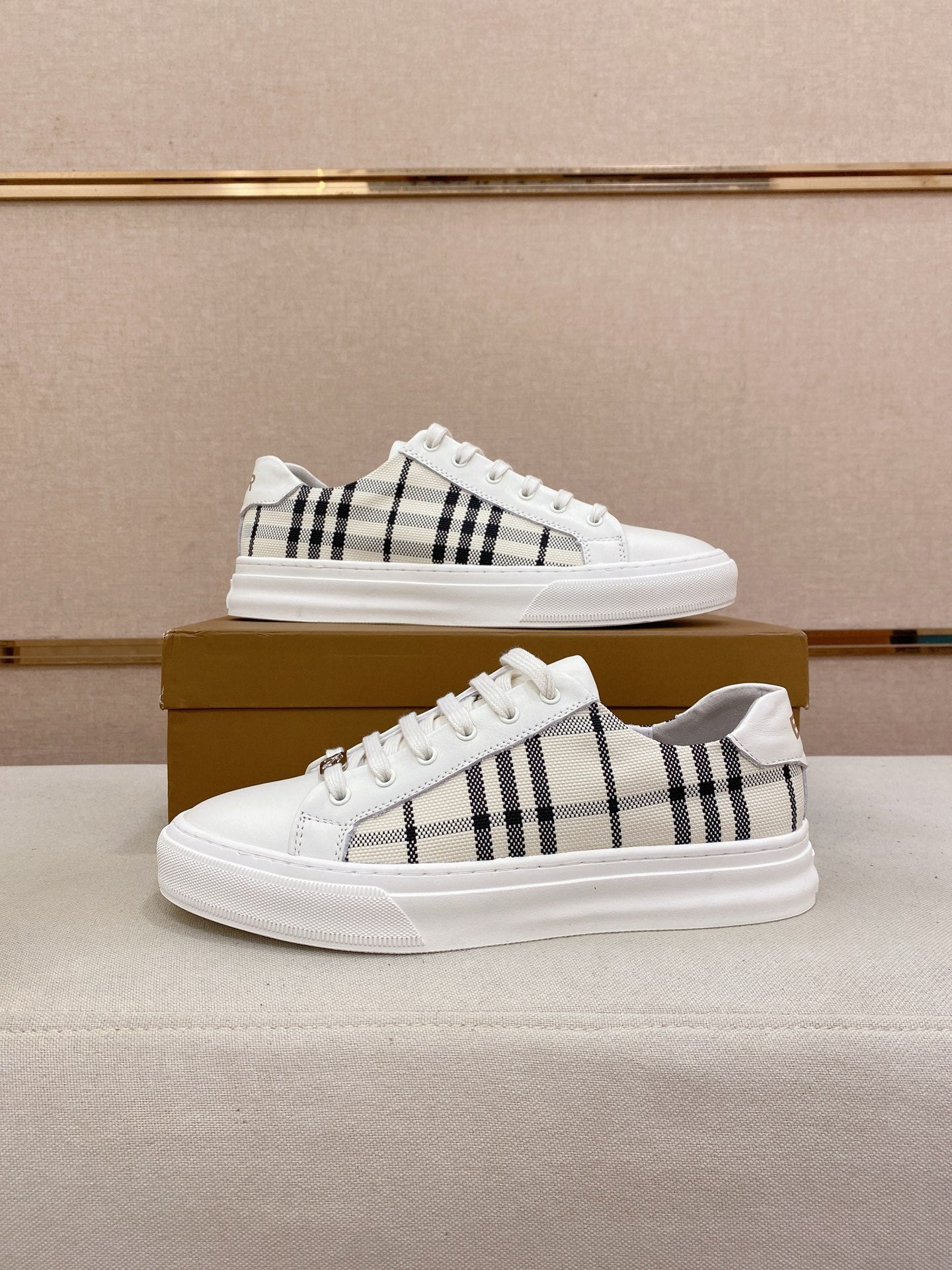 Pair of white Burberry low-top sneakers with black check stripes and lace-up design