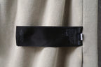 Beige shorts with black inner label tag near waistband