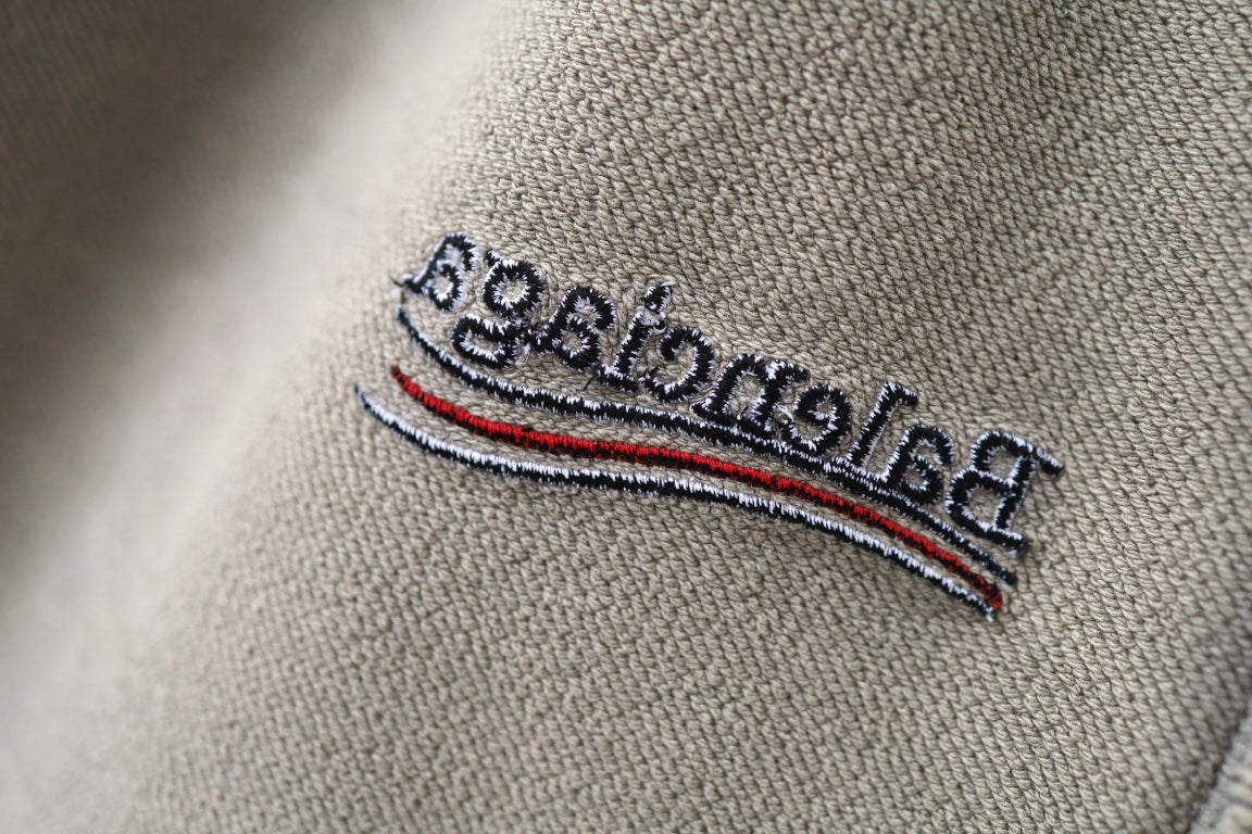 Beige fabric logo patch with embroidered text and multicolor stripe