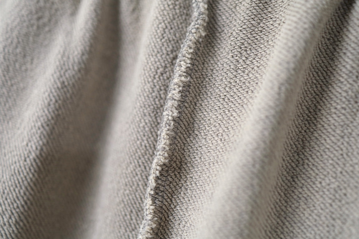 Beige woven fabric close-up with textured surface and seams