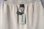 Beige shorts with elastic waistband and attached Balenciaga tags