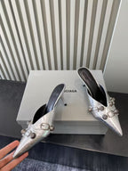 Metallic silver heeled sandals, angled view with pointed toe and buckle detail