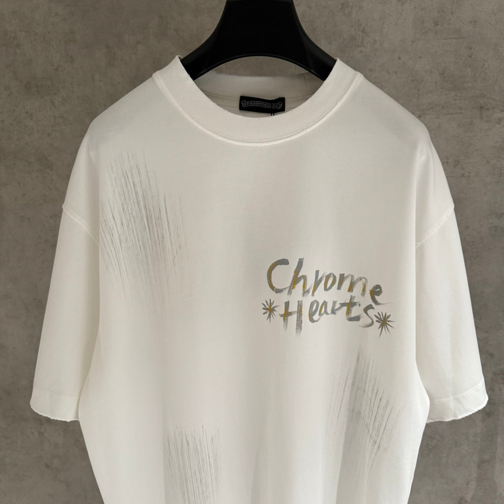 White short-sleeve T-shirt with “Chrome Hearts” logo-style graphic on the chest