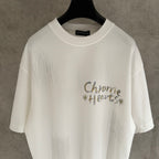 White short-sleeve T-shirt with “Chrome Hearts” logo-style graphic on the chest