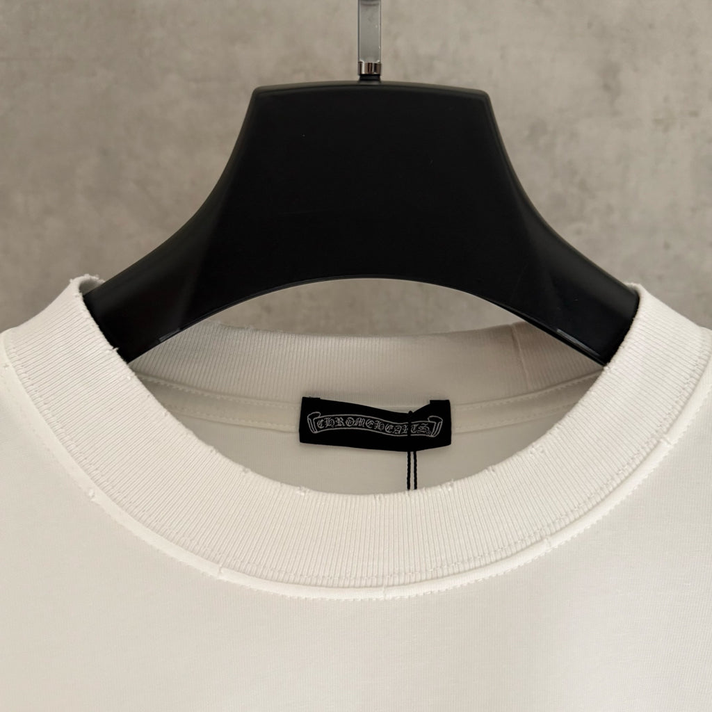 White T-shirt neckline close-up with ribbed collar and small logo patch on the inside