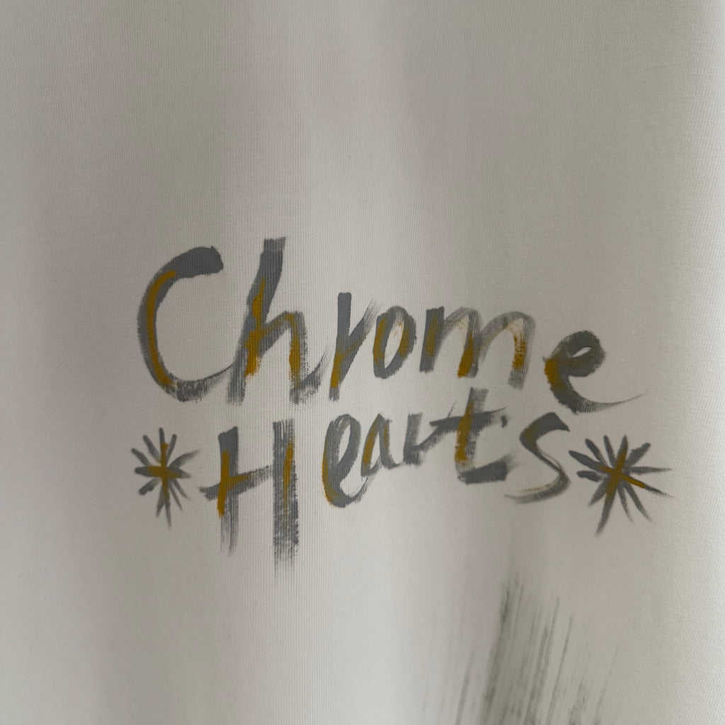 White T-shirt close-up showing “Chrome Hearts” chest graphic