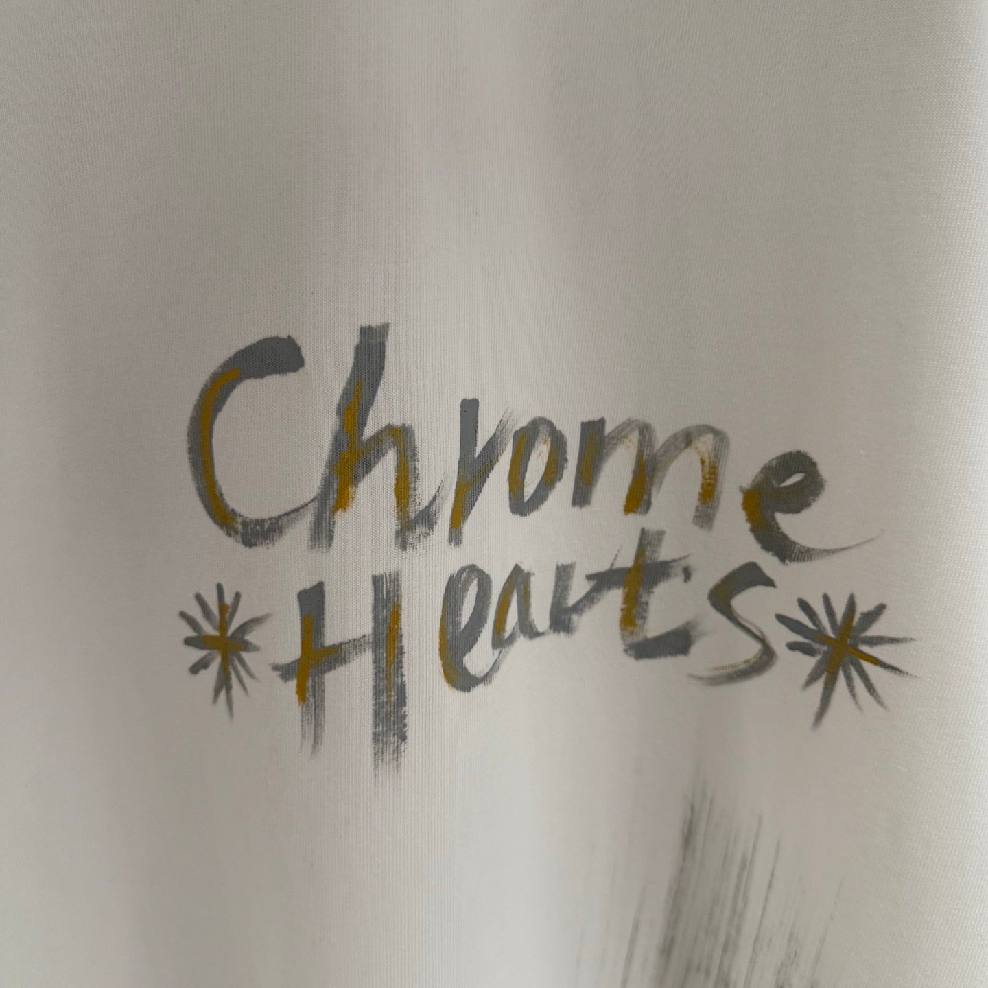 White T-shirt close-up showing “Chrome Hearts” chest graphic
