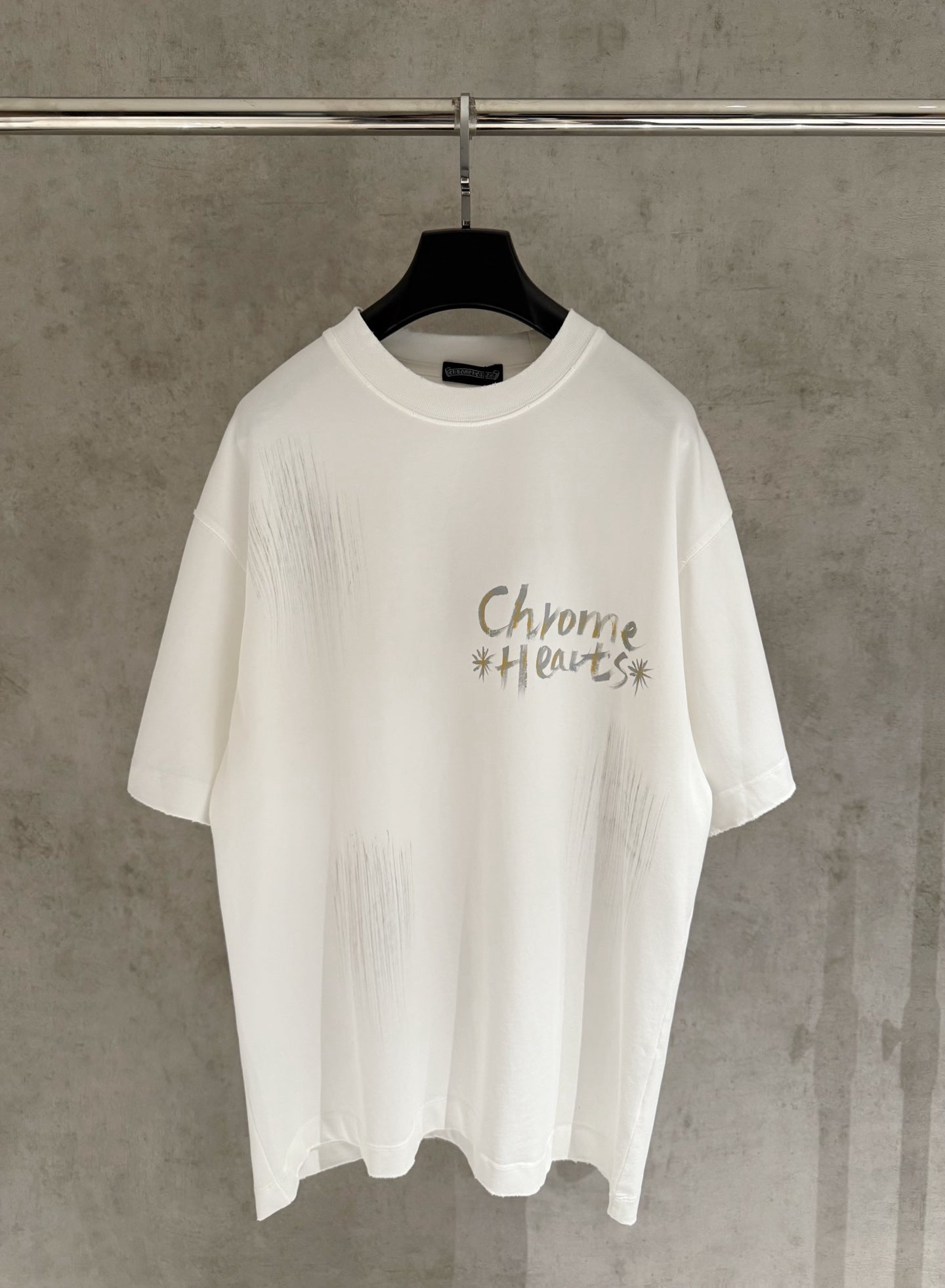White short-sleeve graphic T-shirt with “Chrome Hearts” text on the chest