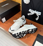 White Chanel sneakers with patterned black-and-white outsole and thick midsole