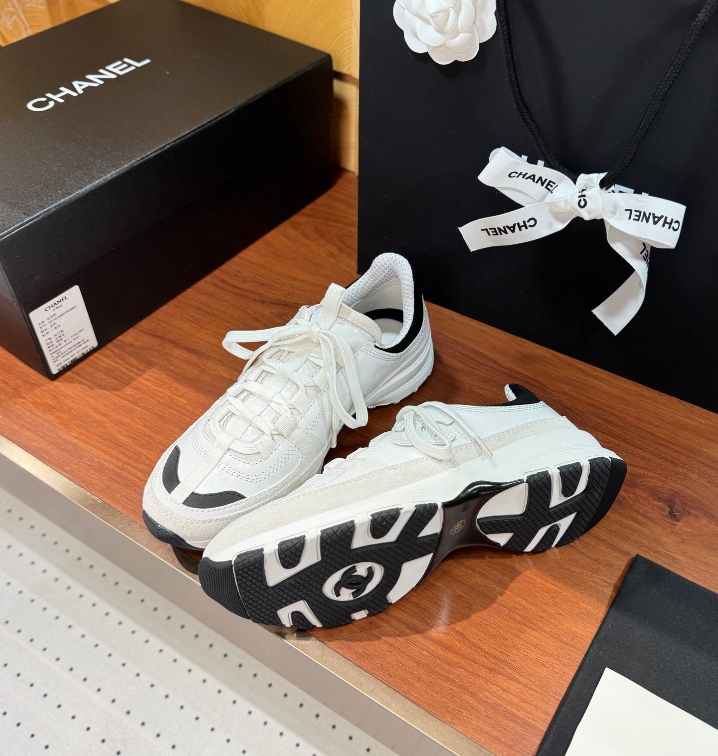 White Chanel sneakers with patterned black-and-white outsole and thick midsole