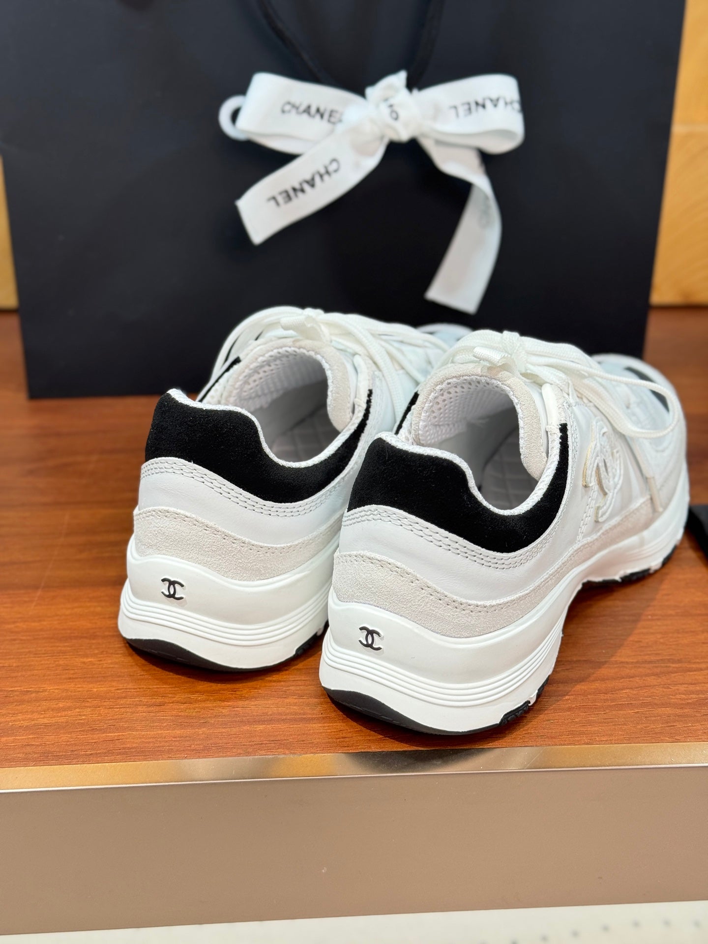 Back view of white Chanel sneakers with black heel collar and rear logo
