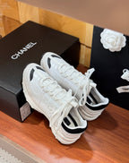 Pair of white Chanel sneakers with black-trim collar and lace-up upper