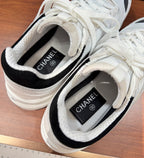 Close-up of Chanel sneaker interior with black tongue label and lace-up opening