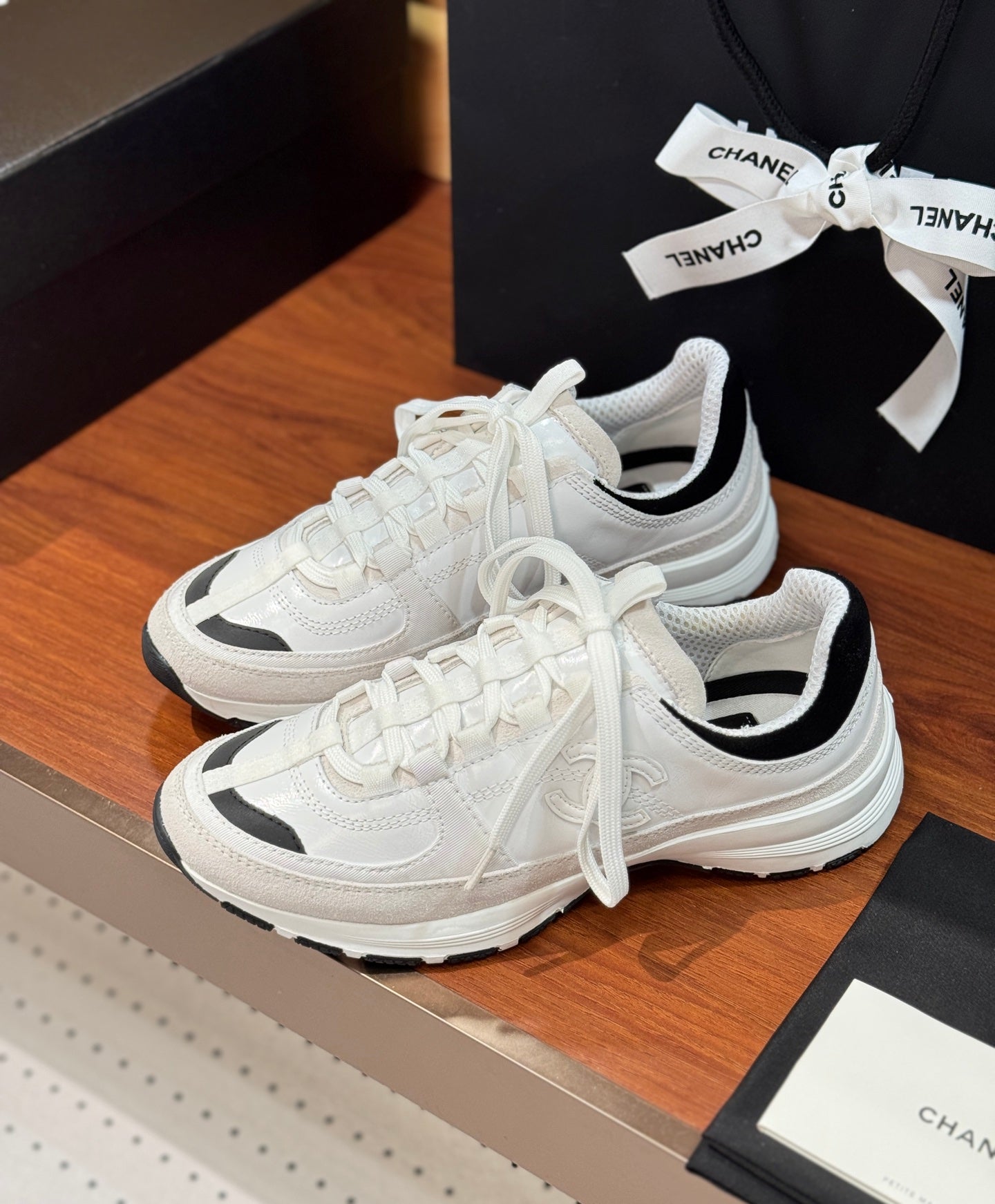 White Chanel sneakers with black collar lining and thick striped rubber sole