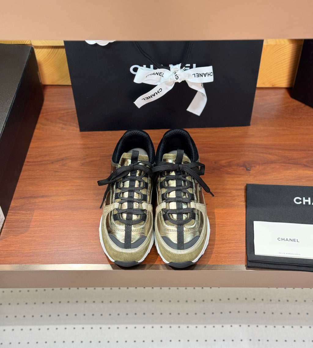 Pair of Chanel sneakers in olive-gold with black laces and white rubber soles