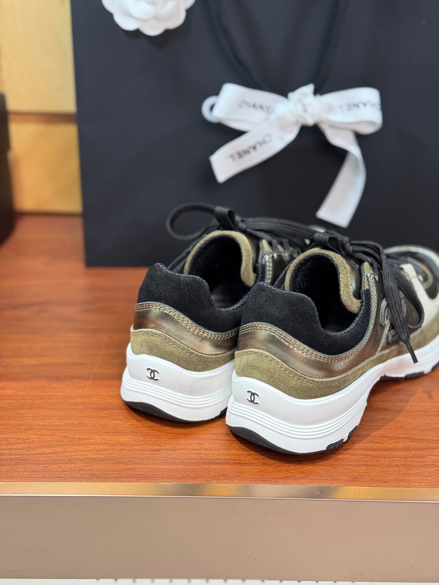 Chanel sneakers back view: olive-gold uppers, black lining, white sole
