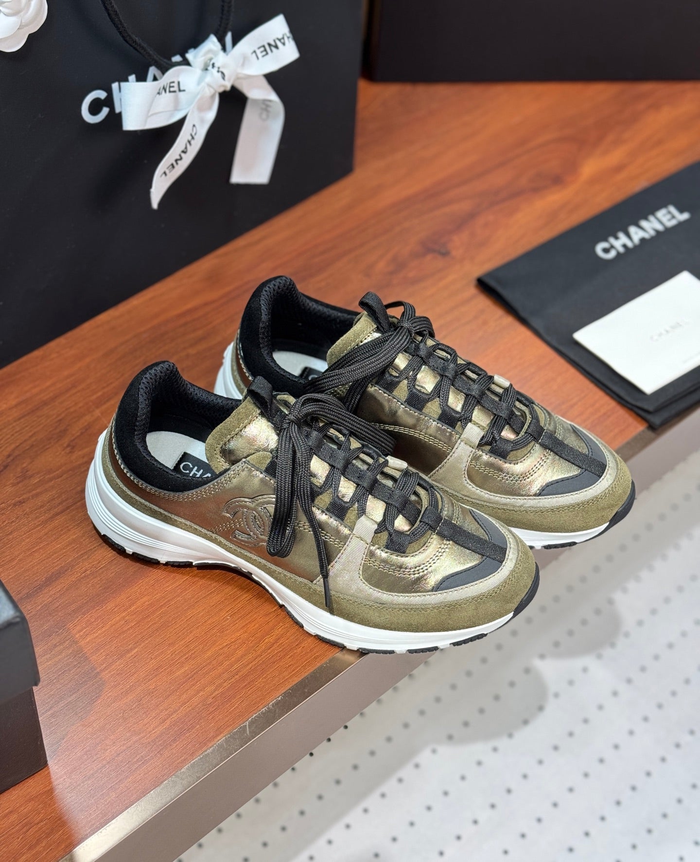 Chanel low-top sneakers, olive-gold uppers with black lace-up and white soles