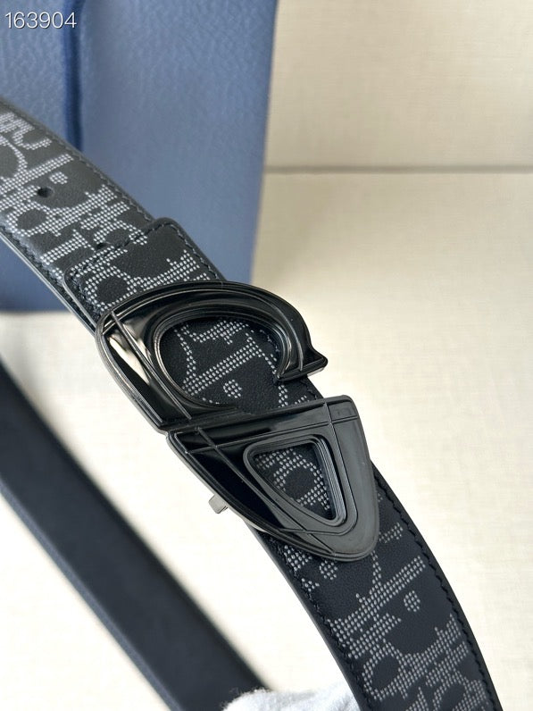 Dior belt close-up with dark monogram strap and dark buckle.