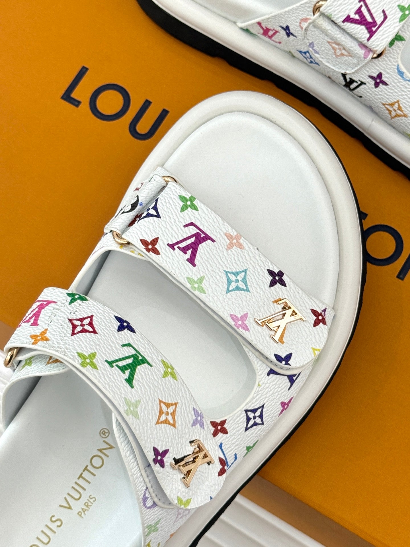 White slide sandal strap with multicolor monogram pattern and gold-tone hardware